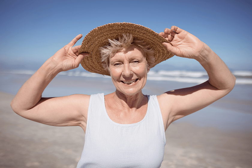 Senior woman wearing sun hat at beach