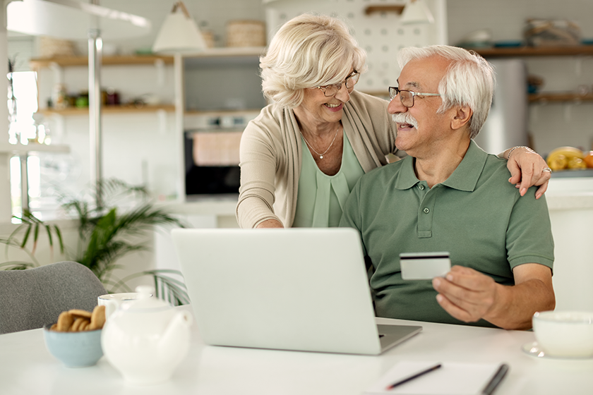 Happy mature couple talking while home shopping